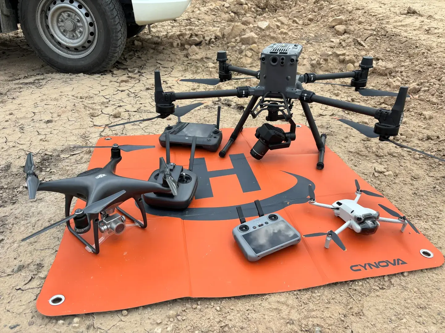 Landair drone fleet laid out on a landing pad: DJI Matrice 350, Phantom 4 and Mini Pro